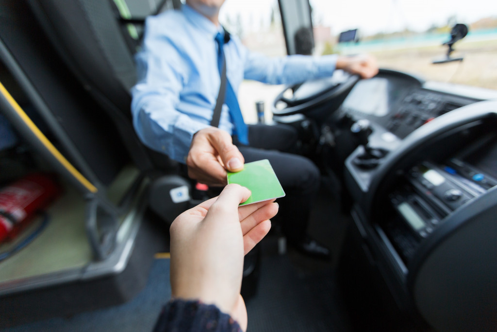 a man handing a travel card to a driver