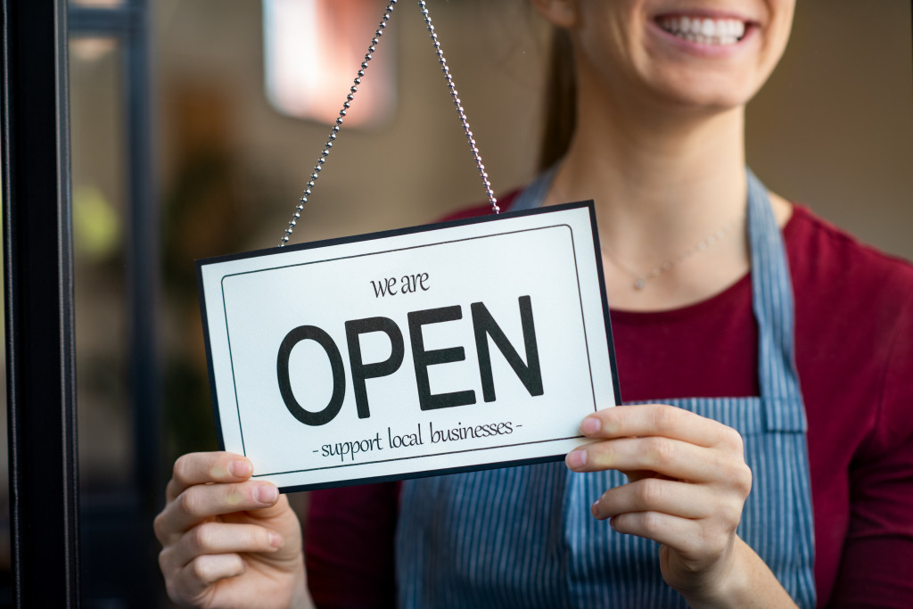 restaurant staff holding the open signage