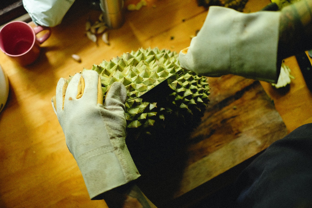 a person cutting durian